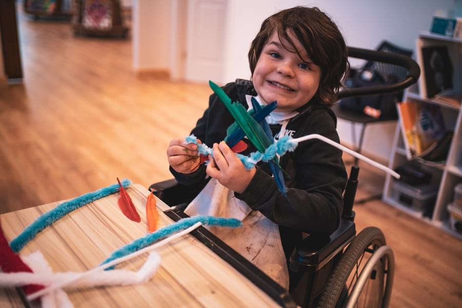 Smiling boy in wheelchair - Art in hands, Shine On